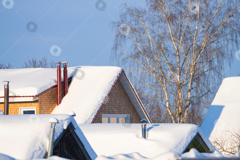 Скачать заснеженные крыши домов с дымоходами, солнечный зимний день фотосток Ozero