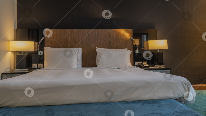 Скачать Спальня готова ко сну. Двуспальная кровать застелена белыми простынями. фотосток Ozero