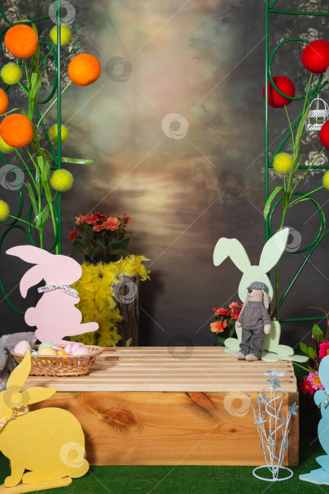 Скачать Пасхальная фотозона с цветными силуэтами кроликов, цветами и деревянной коробкой фотосток Ozero