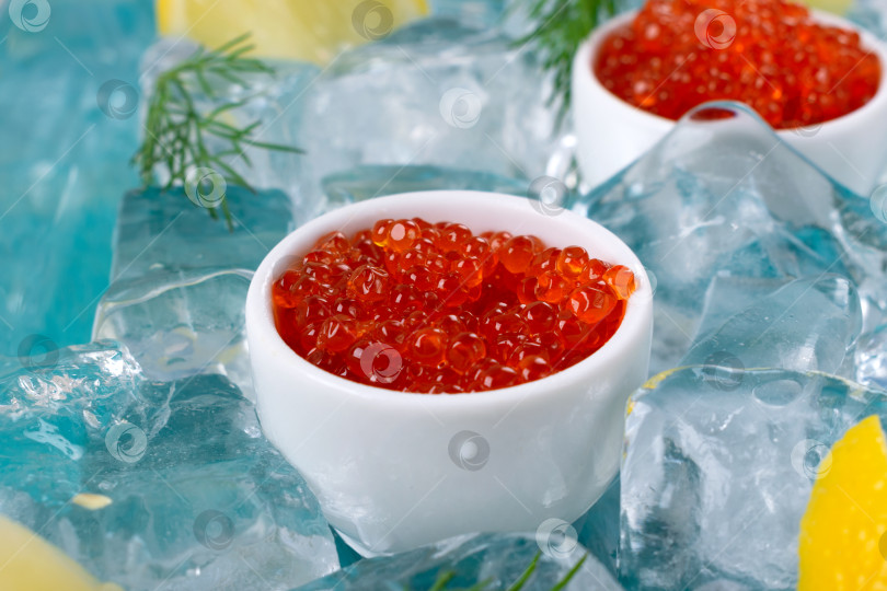 Скачать Красная икра в керамических вазочках, дольки лимона и веточки укропа подаются на льду фотосток Ozero