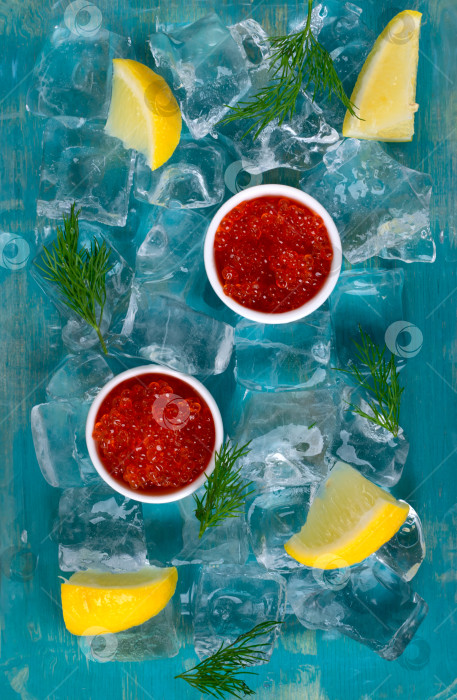 Скачать Красная икра в керамических вазочках, дольки лимона и веточки укропа подаются на льду фотосток Ozero