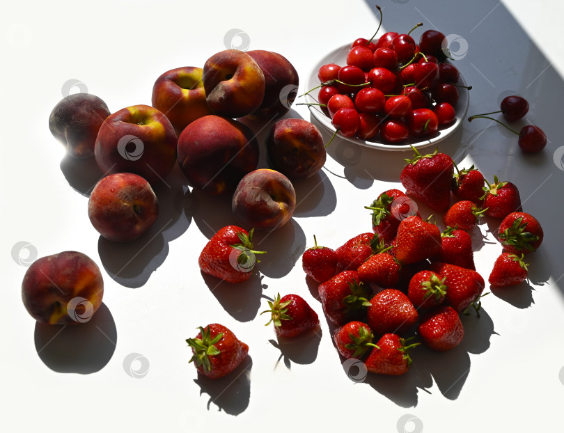 Скачать Летний фуд-арт: клубника, черешня и персики в жестком солнечном свете фотосток Ozero
