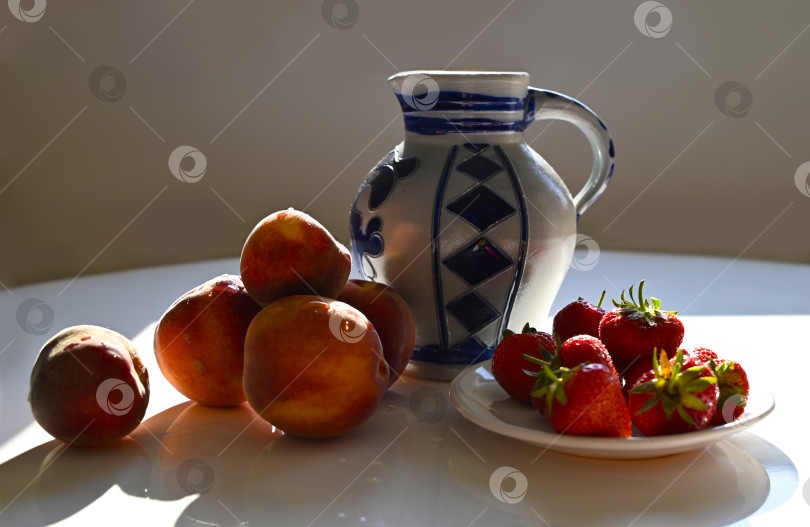 Скачать Ассорти из свежих сезонных ягод и фруктов при ярком освещении фотосток Ozero