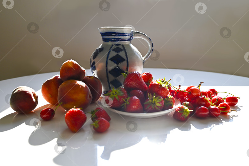 Скачать Утреннее солнце на летнем столе: ягоды, фрукты и керамика фотосток Ozero