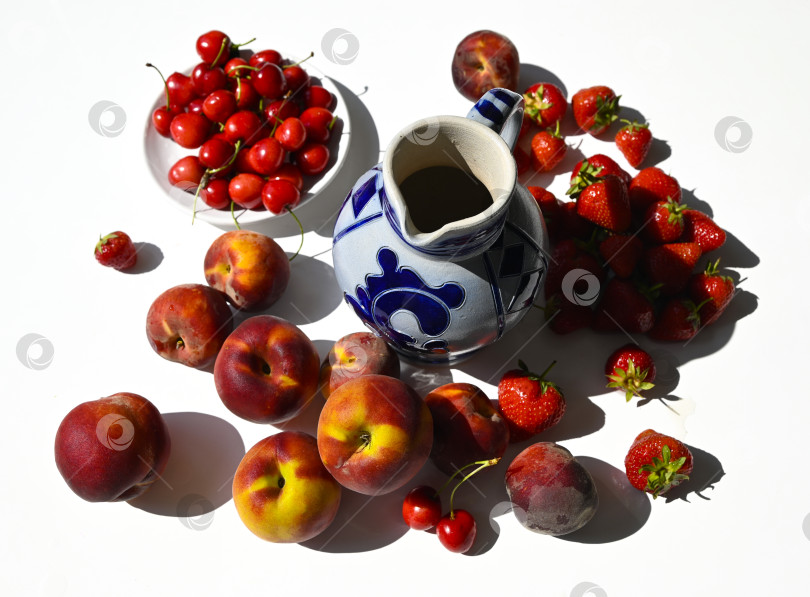 Скачать Летний натюрморт с персиками, ягодами клубники и черешни, и керамическим кувшином фотосток Ozero