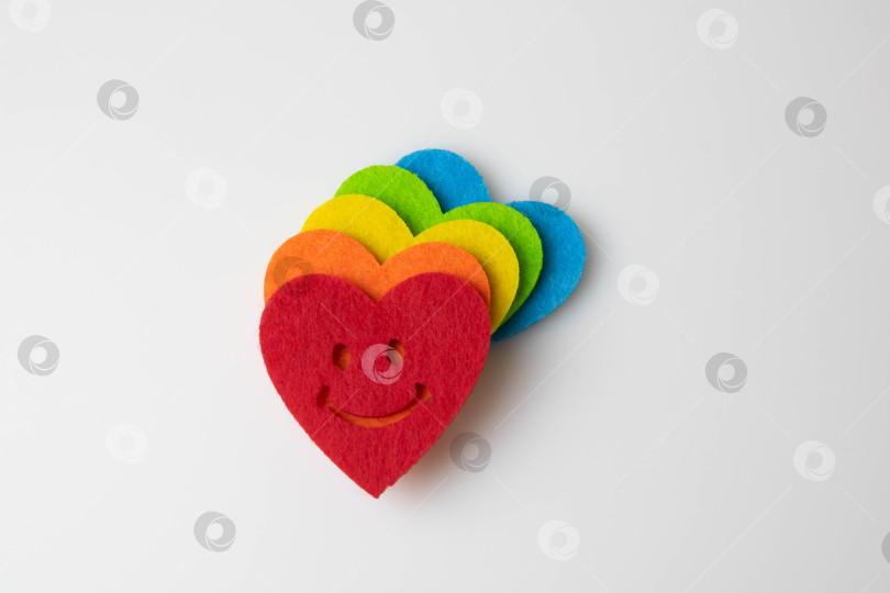Скачать Разноцветные фетровые сердечки на белом фоне. Стоковая фотография ко Дню Святого Валентина с пустым местом для текста. Для Интернета, печати, открыток, приглашений и обоев. фотосток Ozero