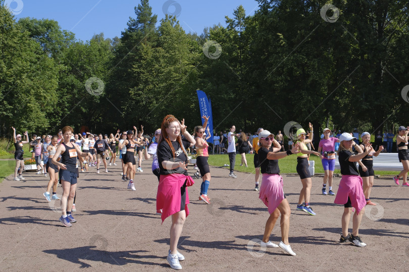Скачать В танцевальном ритме на спортивной площадке перед забегом. Разогрев мышц и настроения. фотосток Ozero