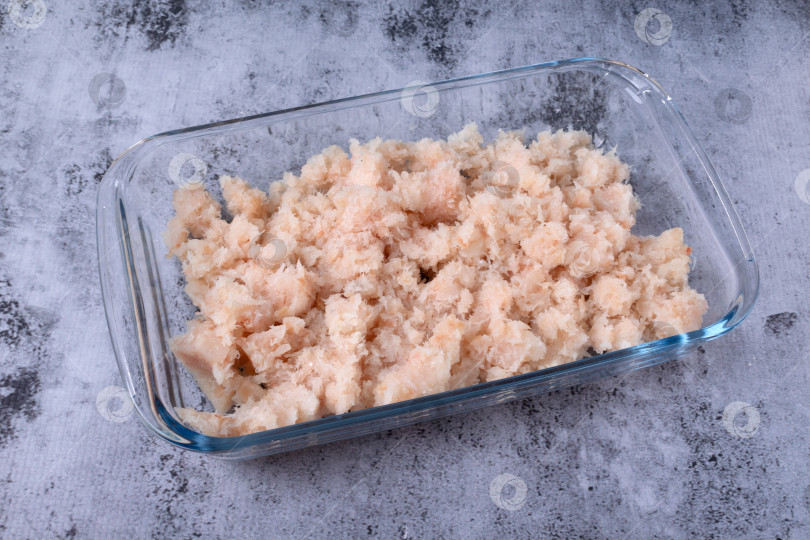 Скачать Фарш из белой рыбы в стеклянной миске на сером фоне фотосток Ozero