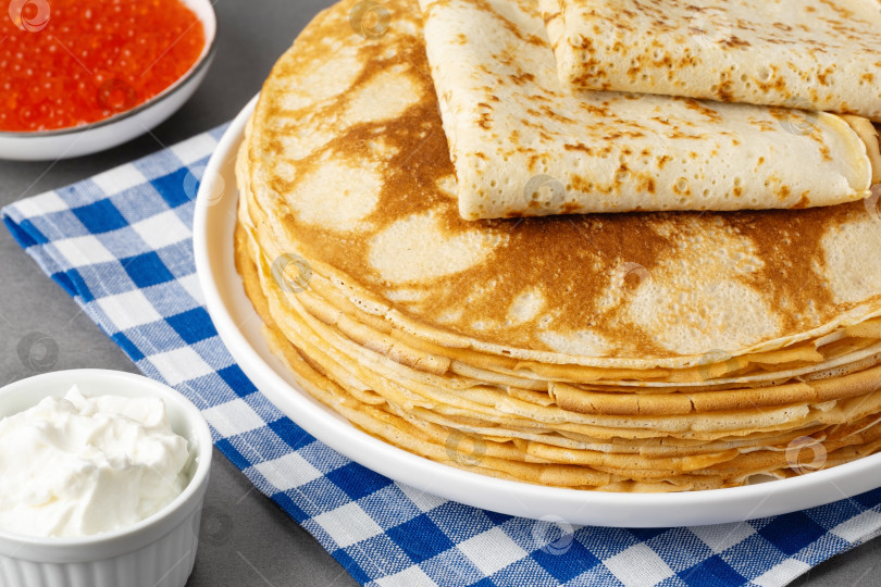 Скачать Свежеиспеченные блинчики со сметаной и красной икрой фотосток Ozero