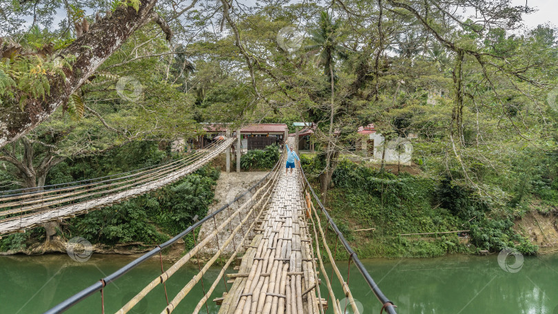 Скачать Шаткий бамбуковый подвесной мост через реку. фотосток Ozero