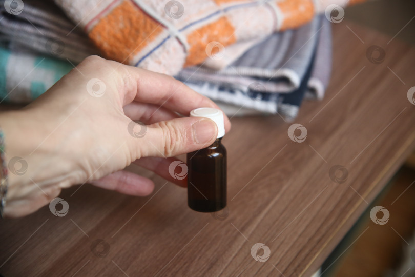 Скачать Пузырёк с кедровым маслом в женской руке фотосток Ozero