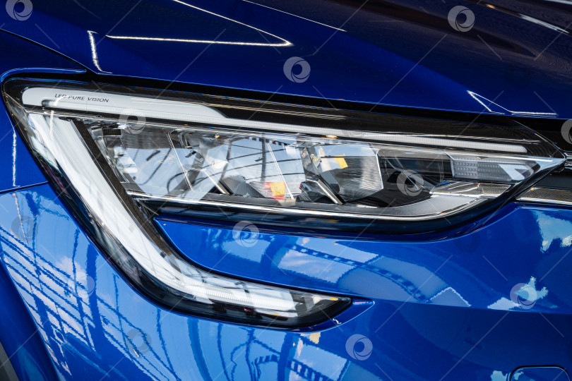 Скачать Синий внедорожник Renault Arkana в автосалоне. Крупным планом - передняя правая фара. Автосалон Renault в Мега Адыгея. фотосток Ozero