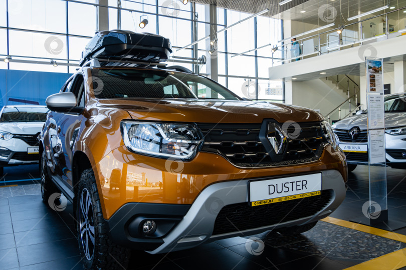 Скачать Внедорожник Renault Duster золотистого цвета с багажником на крыше в автосалоне Renault. Автомобиль крупным планом. Автосалон Renault в Мега Адыгея фотосток Ozero