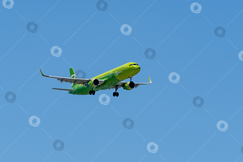 Скачать Airbus A321-200 летит на фоне голубого весеннего неба в аэропорт Адлера. Крупный план. АВИАКОМПАНИЯ "СИБИРЬ". У самолета S7 AIRLINES выпущены шасси и закрылки. Так фотосток Ozero