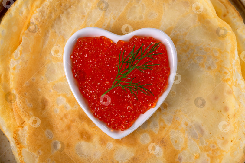 Скачать Традиционные русские тонкие блинчики (крепы) и красная икра в форме сердца крупным планом фотосток Ozero