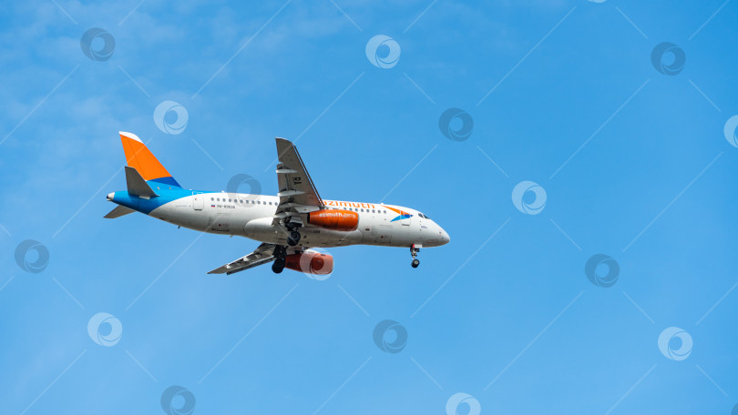 Скачать Sukhoi Superjet-100 SSJ-100-95LR заходит на посадку на взлетно-посадочную полосу аэропорта Адлер. Авиакомпания "Азимут". Выпущены шасси самолета и механики крыла. фотосток Ozero
