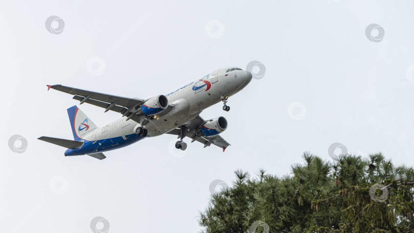 Скачать Sukhoi Superjet-100 SSJ-100-95LR заходит на посадку на взлетно-посадочную полосу аэропорта Адлер. Авиакомпания "Азимут". Выпущены шасси самолета и механики крыла. фотосток Ozero