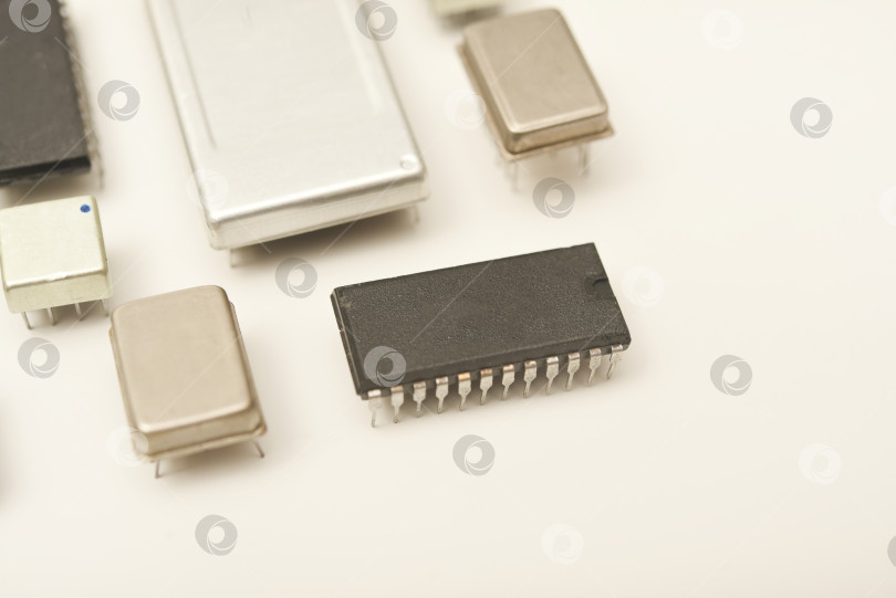 Скачать Старые микросхемы на белом фоне. Электронные компоненты. Процессоры в металлических и пластиковых корпусах. фотосток Ozero