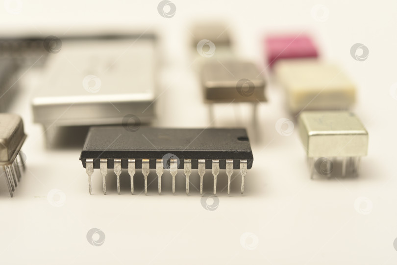 Скачать Старые микросхемы на белом фоне. Электронные компоненты. Процессоры в металлических и пластиковых корпусах. фотосток Ozero