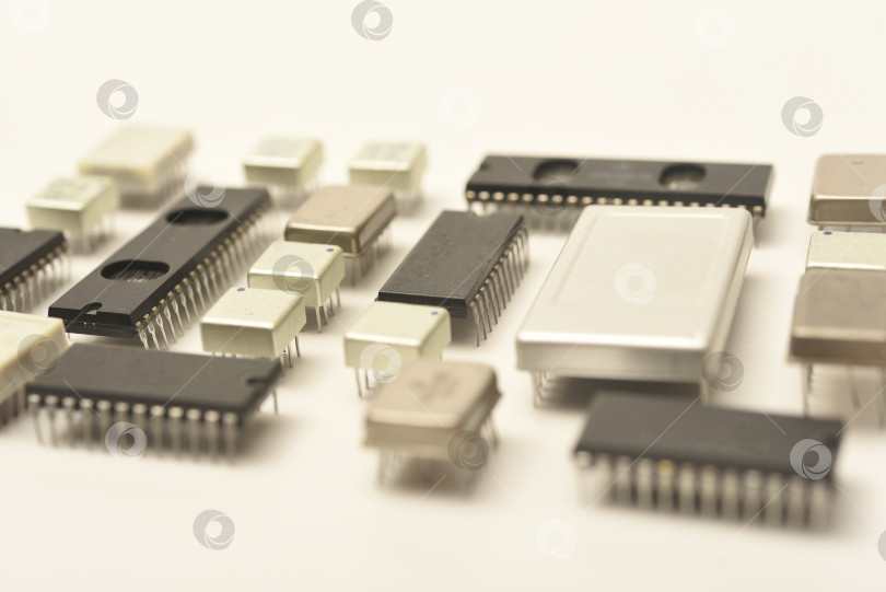 Скачать Старые микросхемы на белом фоне. Электронные компоненты. Процессоры в металлических и пластиковых корпусах. фотосток Ozero