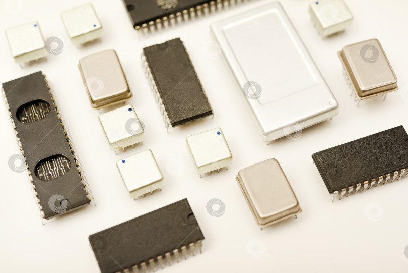 Скачать Старые микросхемы на белом фоне. Электронные компоненты. Процессоры в металлических и пластиковых корпусах. фотосток Ozero