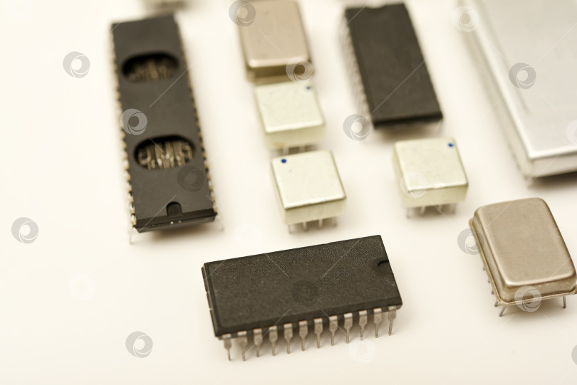 Скачать Старые микросхемы на белом фоне. Электронные компоненты. Процессоры в металлических и пластиковых корпусах. фотосток Ozero