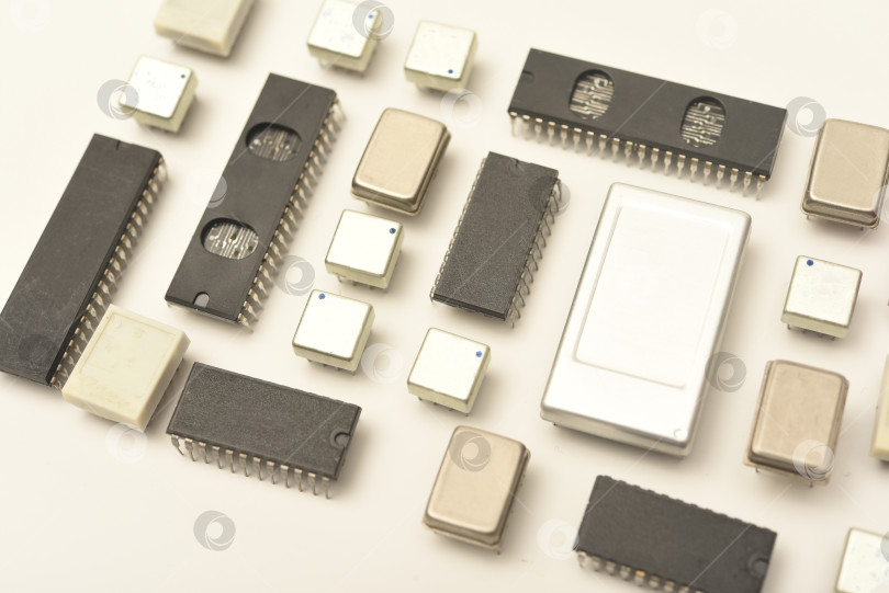 Скачать Старые микросхемы на белом фоне. Электронные компоненты. Процессоры в металлических и пластиковых корпусах. фотосток Ozero