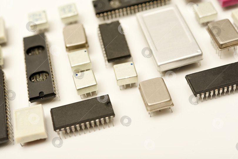Скачать Старые микросхемы на белом фоне. Электронные компоненты. Процессоры в металлических и пластиковых корпусах. фотосток Ozero