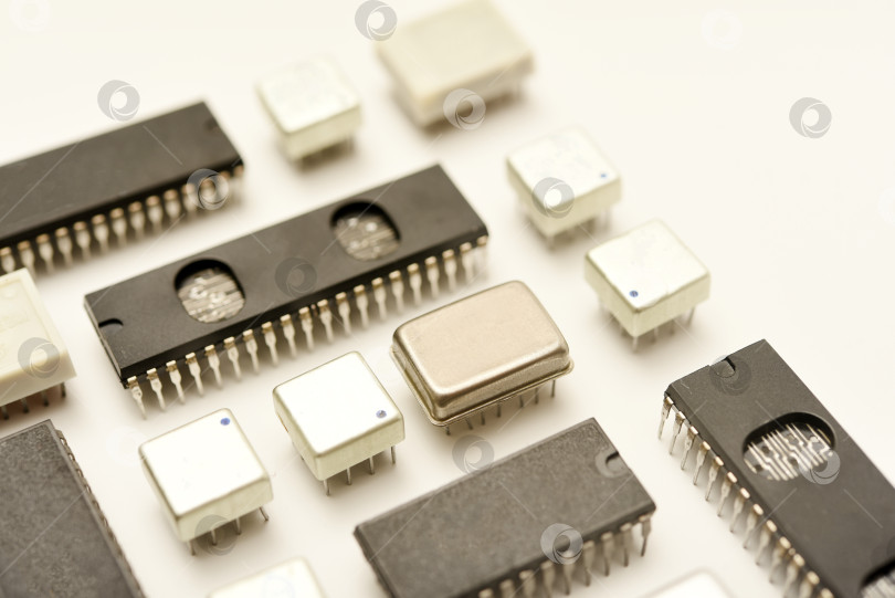 Скачать Старые микросхемы на белом фоне. Электронные компоненты. Процессоры в металлических и пластиковых корпусах. фотосток Ozero