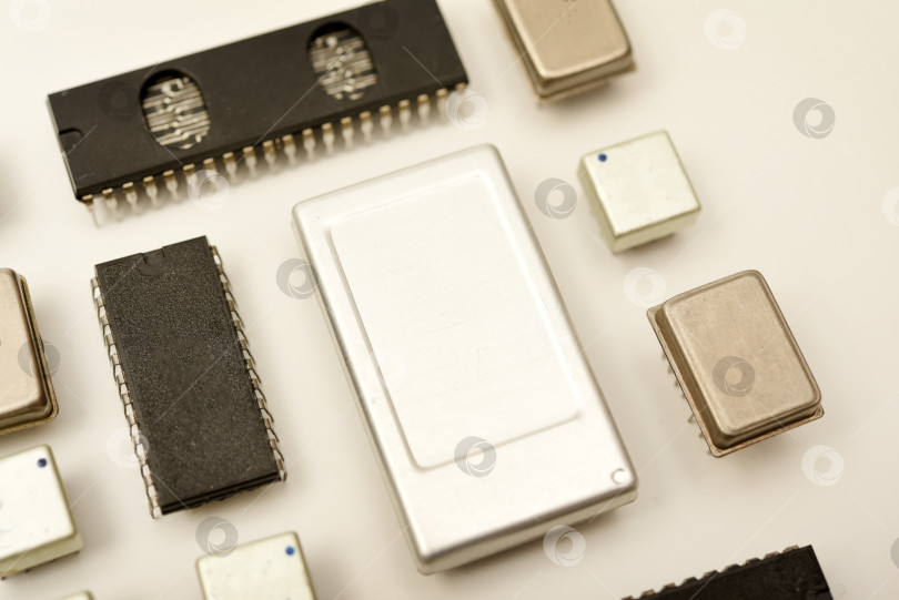 Скачать Старые микросхемы на белом фоне. Электронные компоненты. Процессоры в металлических и пластиковых корпусах. фотосток Ozero