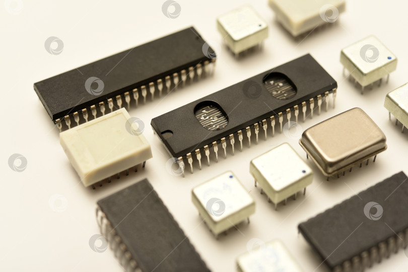 Скачать Старые микросхемы на белом фоне. Электронные компоненты. Процессоры в металлических и пластиковых корпусах. фотосток Ozero