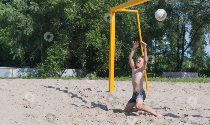 Скачать Маленький мальчик играет в футбол на песке фотосток Ozero