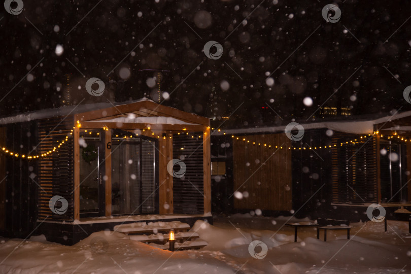Скачать пейзаж жилого дома ночью во время снегопада с включенным освещением фотосток Ozero