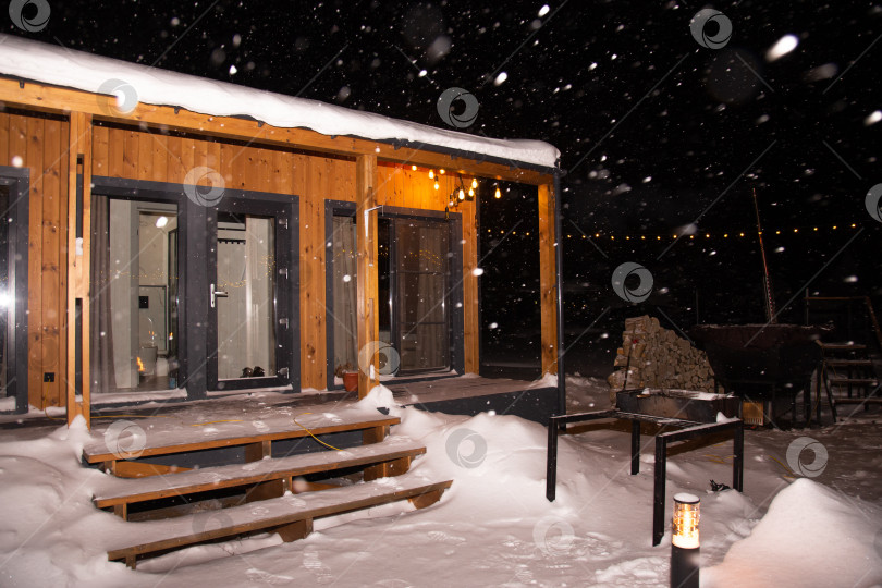 Скачать пейзаж жилого дома ночью во время снегопада с включенным освещением фотосток Ozero