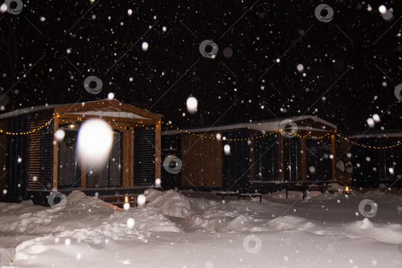 Скачать пейзаж жилого дома ночью во время снегопада с включенным освещением фотосток Ozero