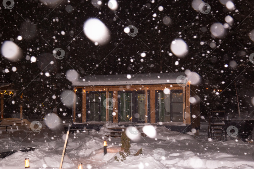 Скачать пейзаж жилого дома ночью во время снегопада с включенным освещением фотосток Ozero