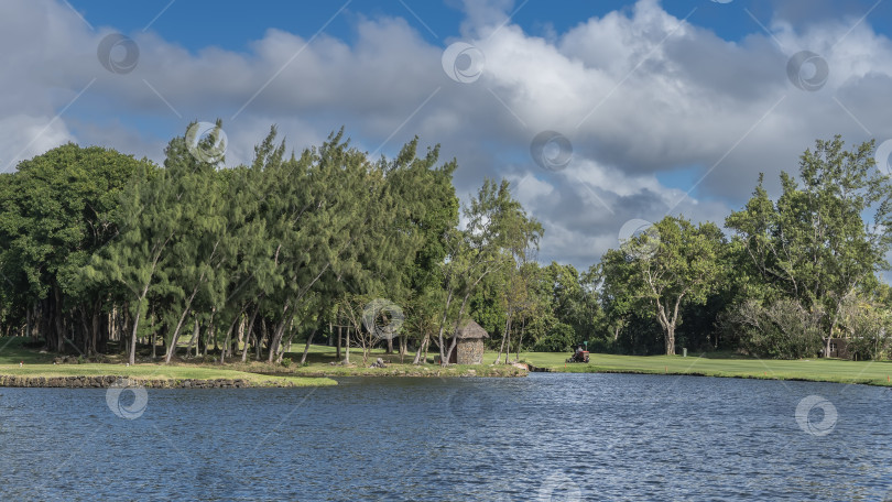 Скачать Спокойное голубое озеро рядом с полем для гольфа. Рябь на воде. фотосток Ozero