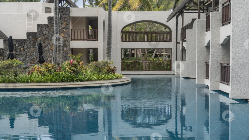 Скачать Голубой бассейн. Здание с балконами и террасами прямо у воды. фотосток Ozero