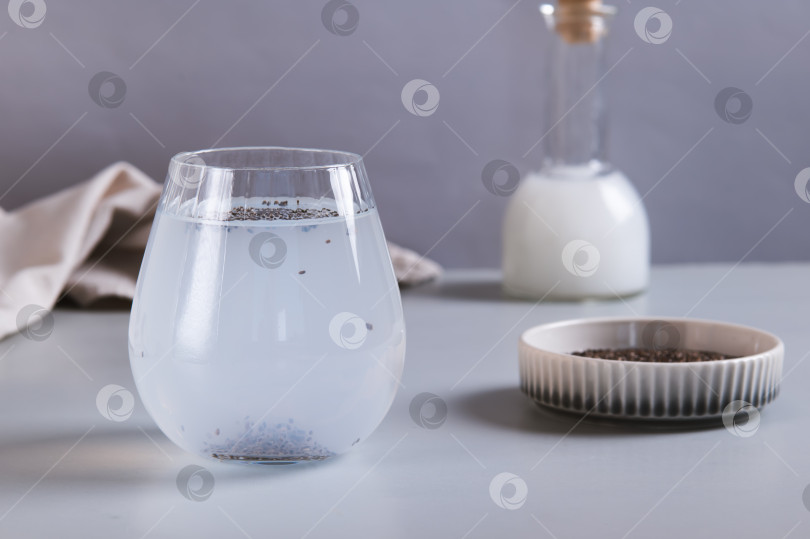 Скачать Детокс-кокосовая вода с семенами чиа в стакане на столе фотосток Ozero