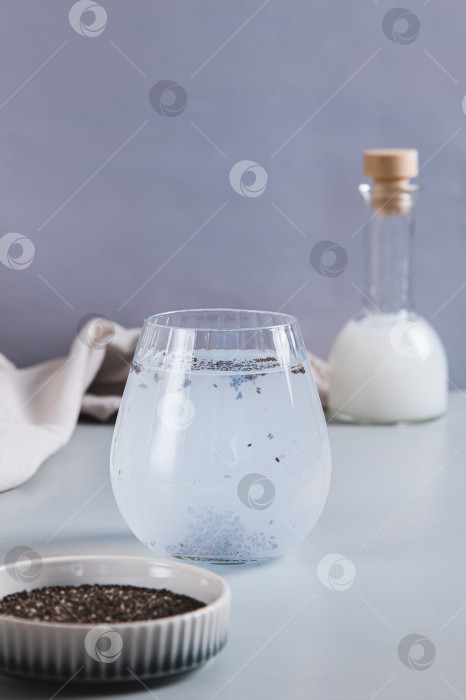 Скачать Детокс-кокосовая вода с семенами чиа в стакане на столе, вид сверху фотосток Ozero