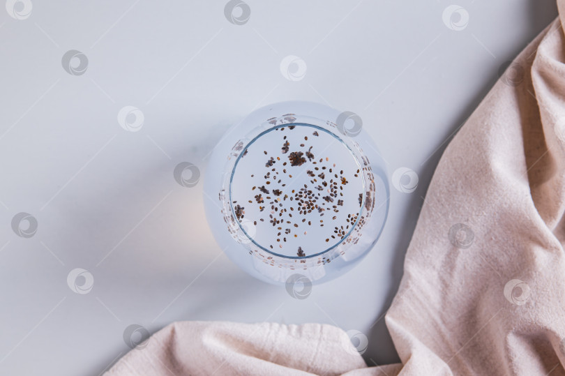 Скачать Крупный план кокосовой воды для детоксикации с семенами чиа в стакане на столе, вид сверху фотосток Ozero