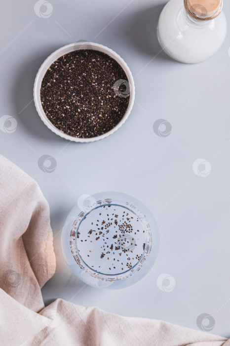 Скачать Освежающий напиток на кокосовой воде с семенами чиа в бокале на столешнице в вертикальном положении фотосток Ozero