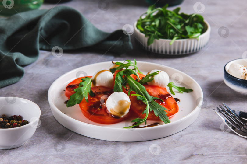 Скачать Средиземноморский салат капрезе с рукколой на тарелке на столе фотосток Ozero