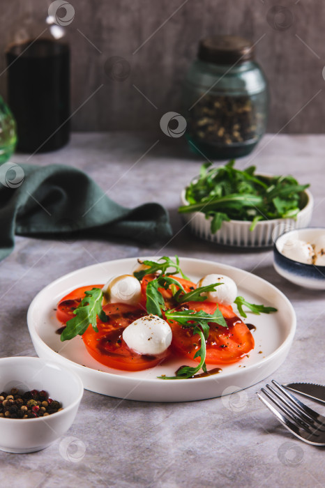 Скачать Средиземноморский салат капрезе с рукколой на тарелке на столе, вид сверху фотосток Ozero