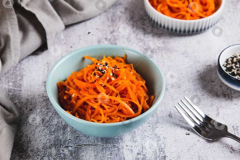 Скачать Острая корейская морковь с кунжутом в миске на столе фотосток Ozero
