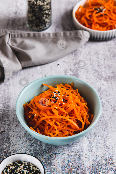 Скачать Острая корейская морковь с кунжутом в миске на столе, вид сверху фотосток Ozero