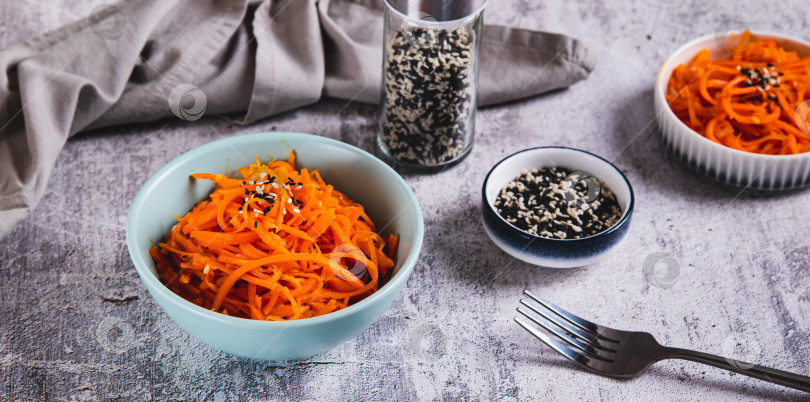 Скачать Корейская морковь с кунжутом в миске на столе веб-баннер фотосток Ozero