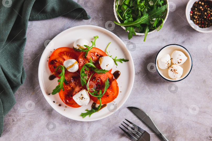 Скачать Средиземноморский салат капрезе с рукколой на тарелке на столе вид сверху фотосток Ozero