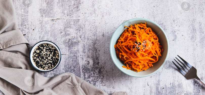 Скачать Острая корейская морковь с кунжутом в миске на столешнице посмотреть веб-баннер фотосток Ozero