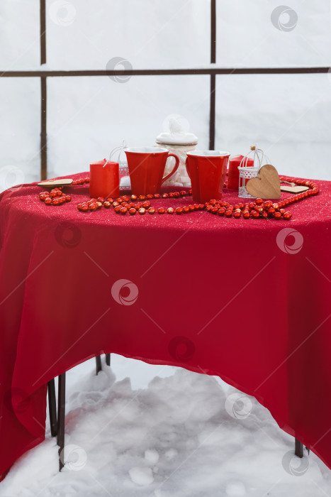 Скачать Романтическая сервировка стола на День святого Валентина в зимнее время в беседке на открытом воздухе, оформленной в красном стиле фотосток Ozero